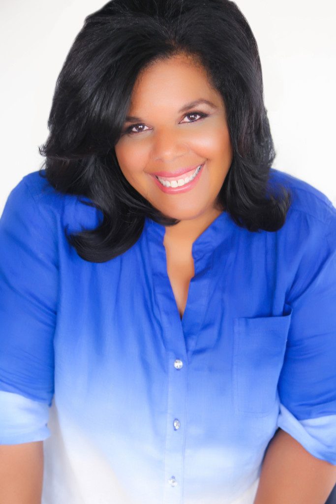Mariana Cooper in a blue blouse, photographed against a soft white background